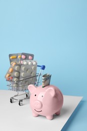 Piggy bank, pills and money on colorful background, space for text. Medical insurance