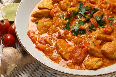 Delicious chicken curry and ingredients on table, closeup