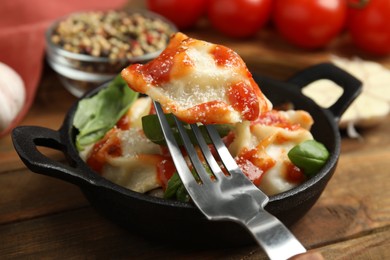 Photo of Tasty ravioli with tomato sauce served on wooden table, closeup