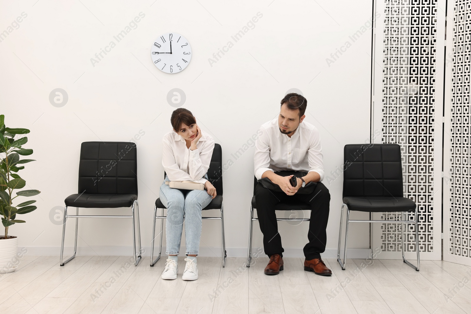 Photo of Man and woman waiting for job interview indoors