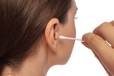 Photo of Young woman cleaning ear with cotton swab on white background, closeup