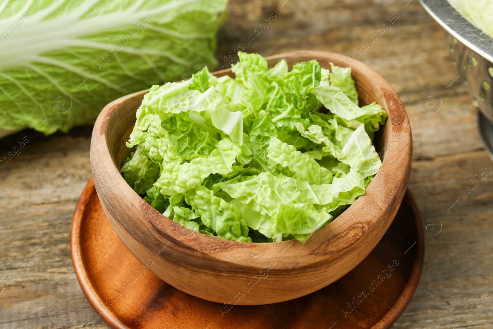 Photo of Cut fresh Chinese cabbage on wooden table, closeup