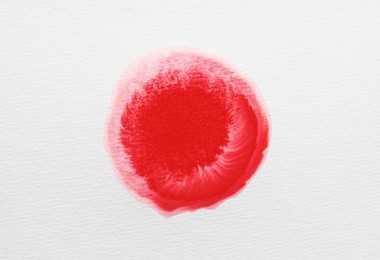 Photo of Blot of red ink on white background, top view