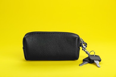 Photo of Leather case with keys on yellow background