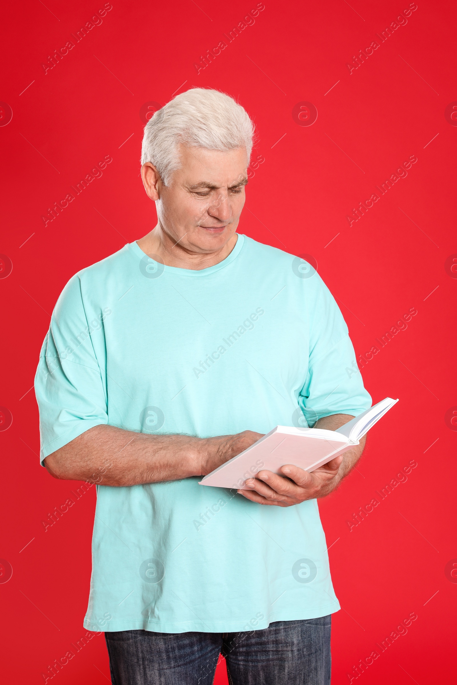 Photo of Senior man reading book on color background