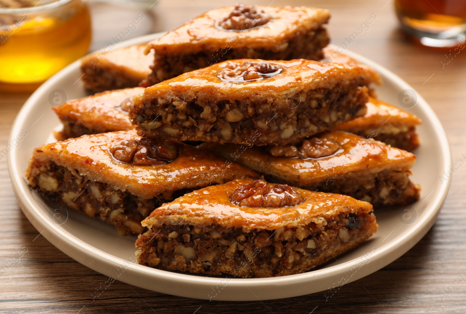 Photo of Delicious sweet baklava with walnuts on wooden table, closeup