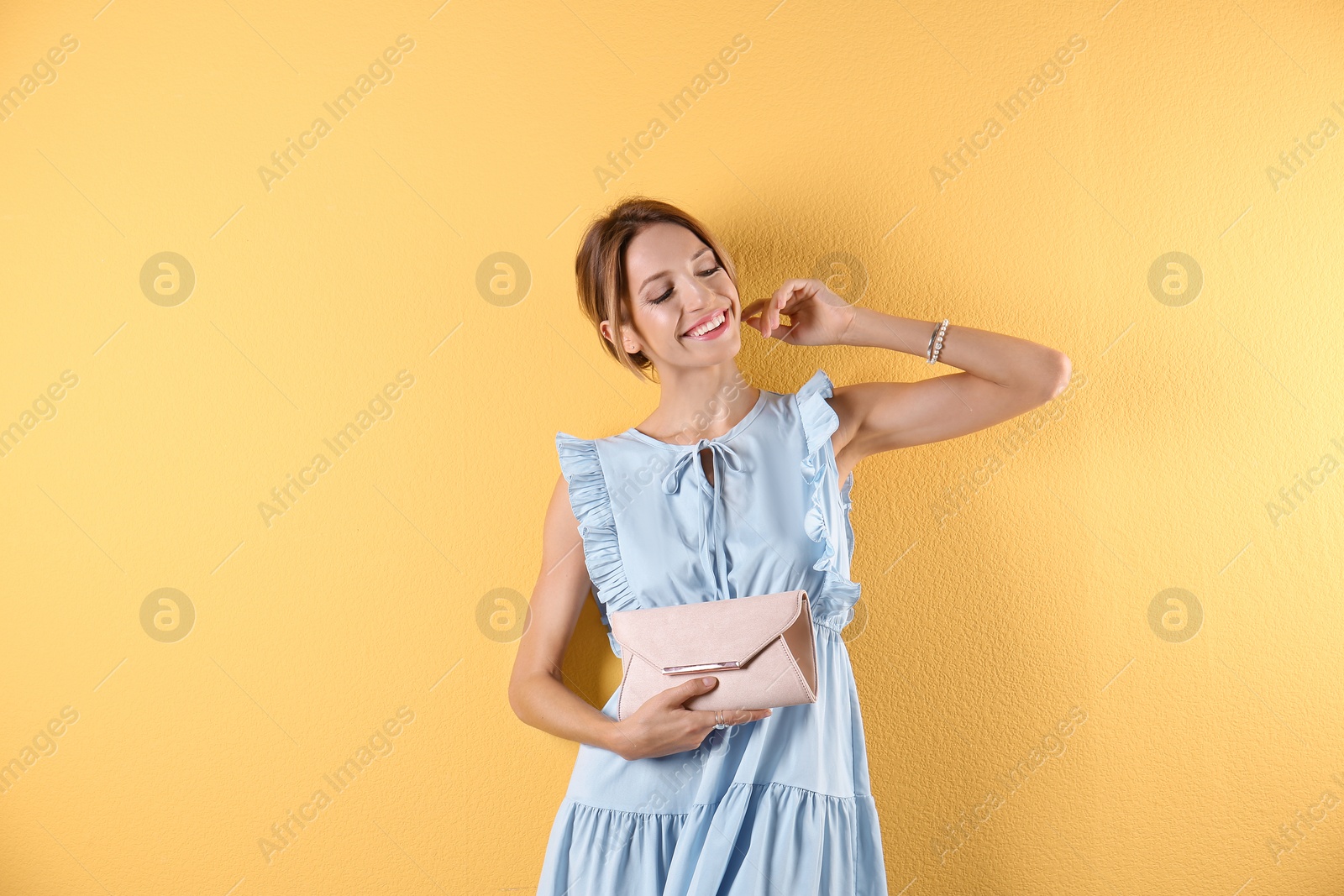 Photo of Portrait of young woman in stylish outfit with purse on color background