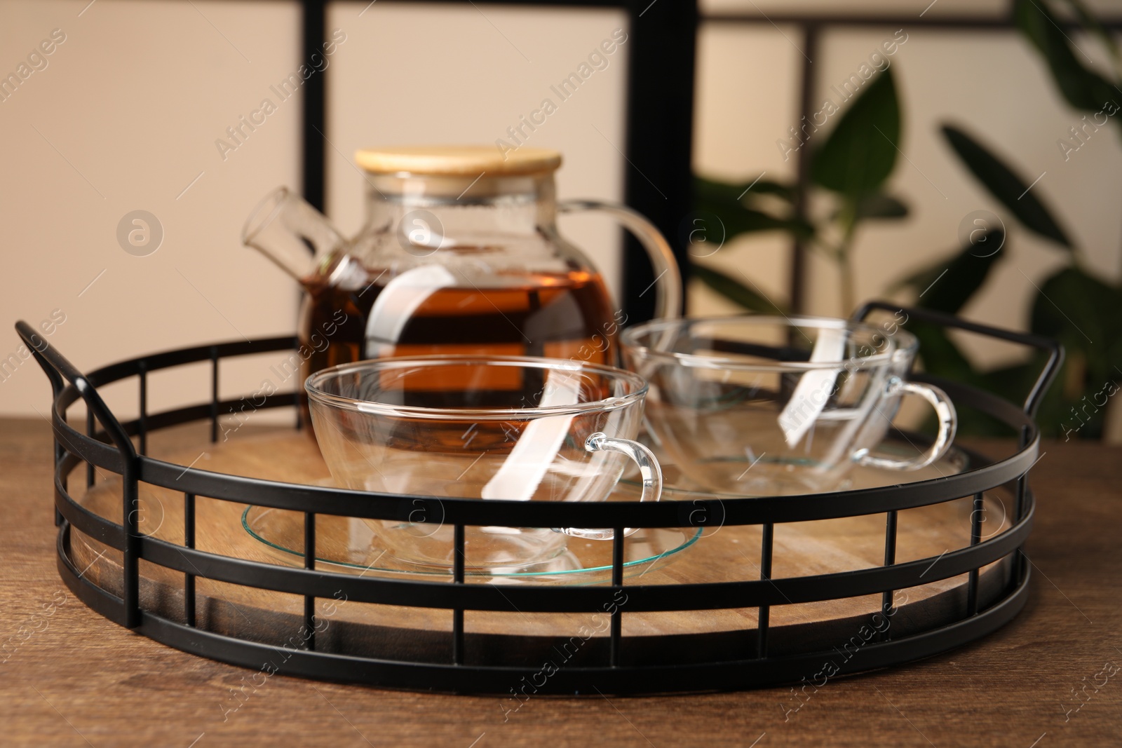 Photo of Tray with clean glass cups and teapot on wooden table