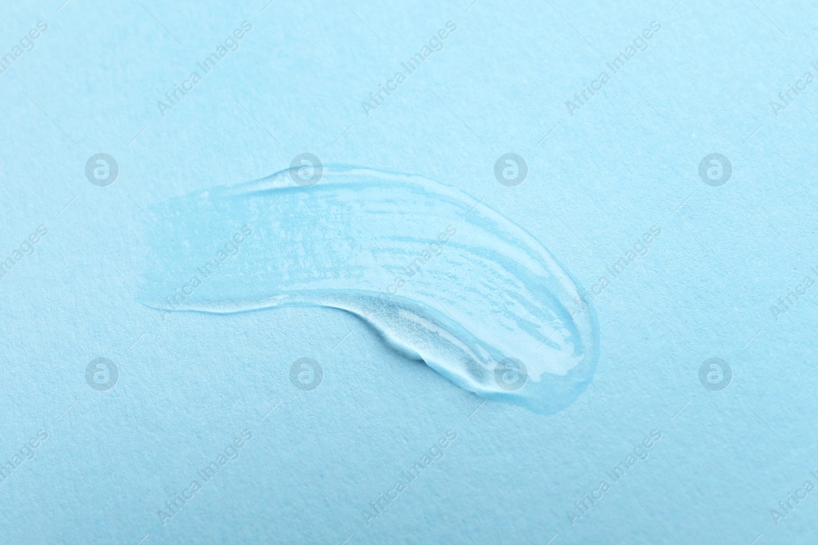 Photo of Swatch of cosmetic gel on light blue background, top view