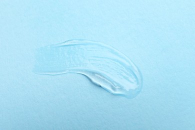 Photo of Swatch of cosmetic gel on light blue background, top view