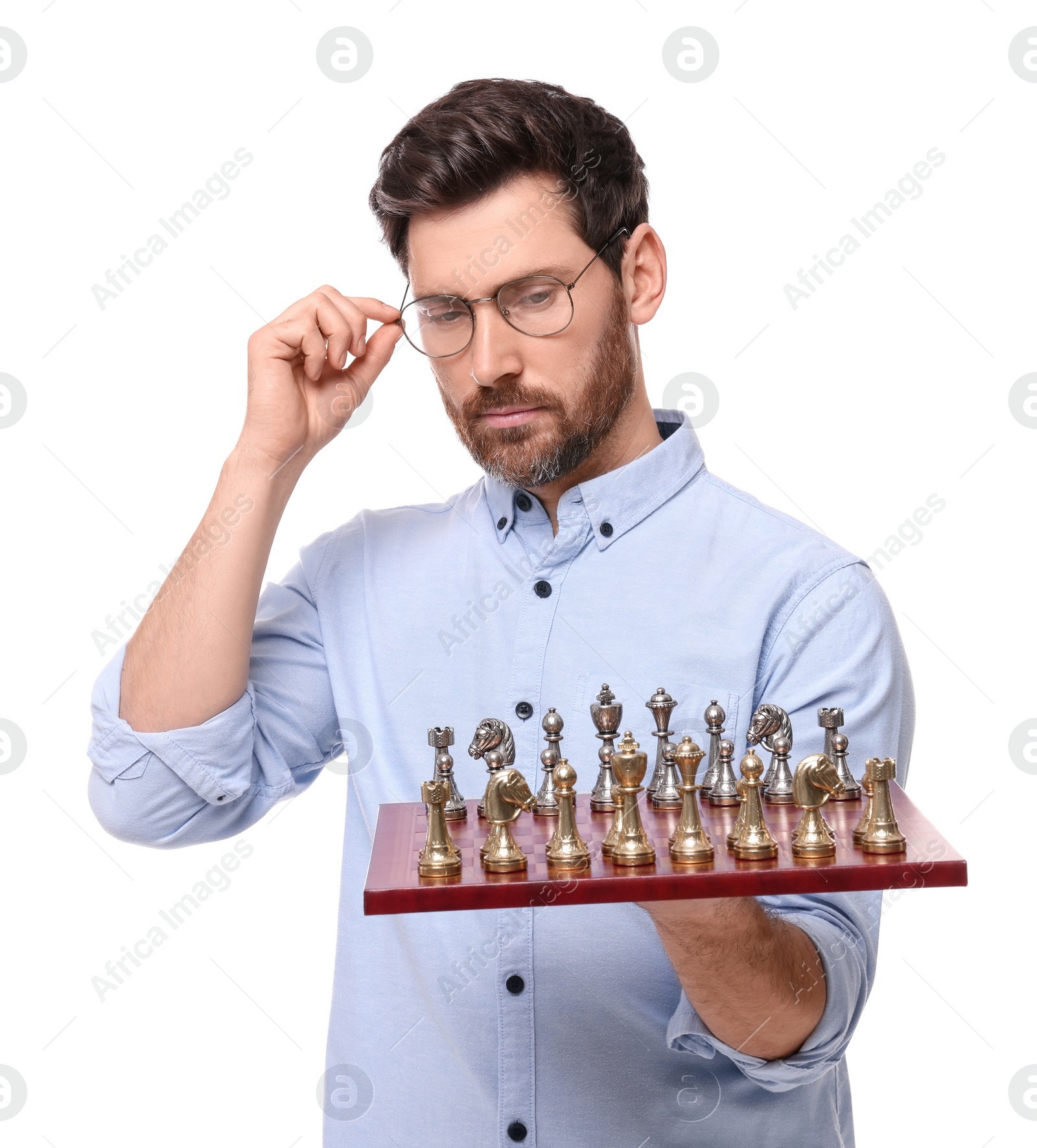 Photo of Thoughtful man holding chessboard with game pieces on white background