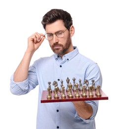 Photo of Thoughtful man holding chessboard with game pieces on white background