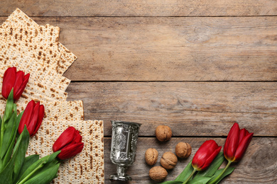 Flat lay composition with matzos on wooden background, space for text. Passover (Pesach) celebration