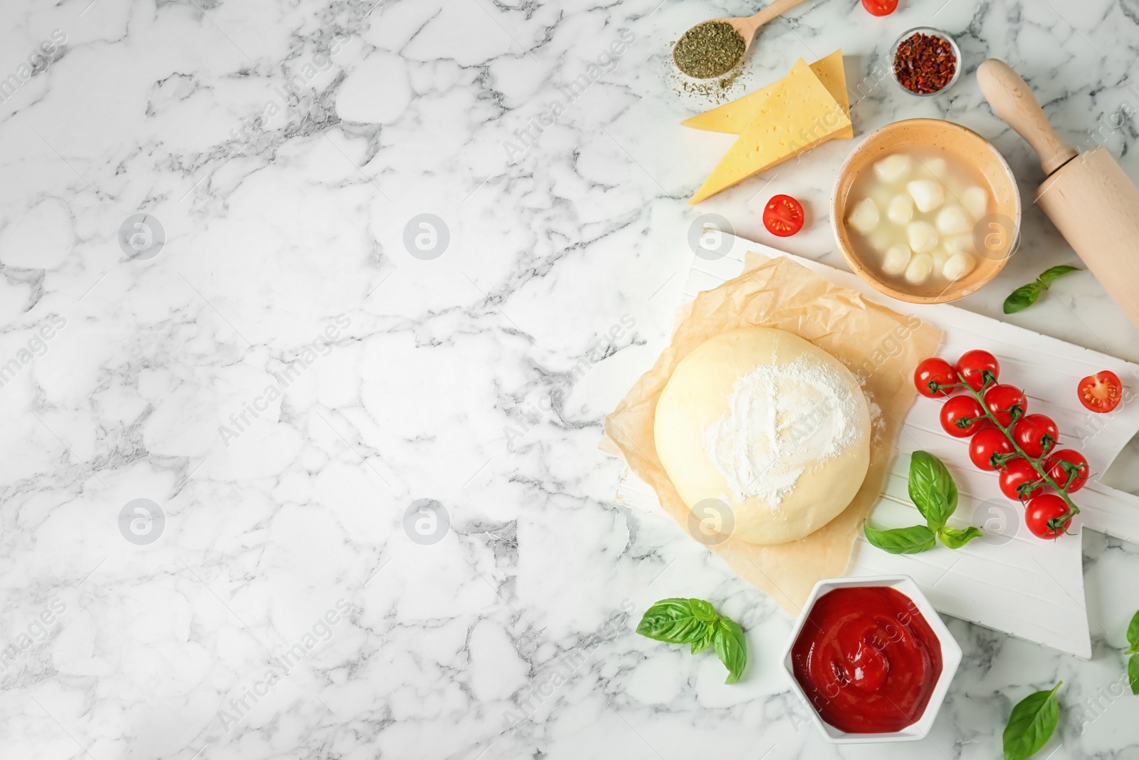 Photo of Dough and ingredients for pizza on marble background, top view