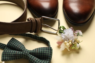 Photo of Wedding stuff. Composition with stylish boutonniere on yellow background, closeup