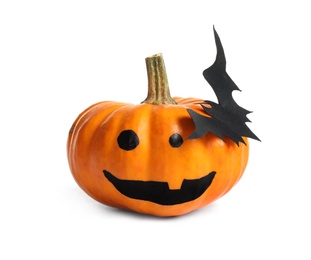 Photo of Halloween pumpkin with cute drawn face and paper bat isolated on white