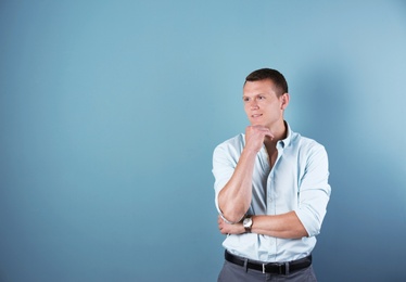 Thoughtful handsome young man on color background