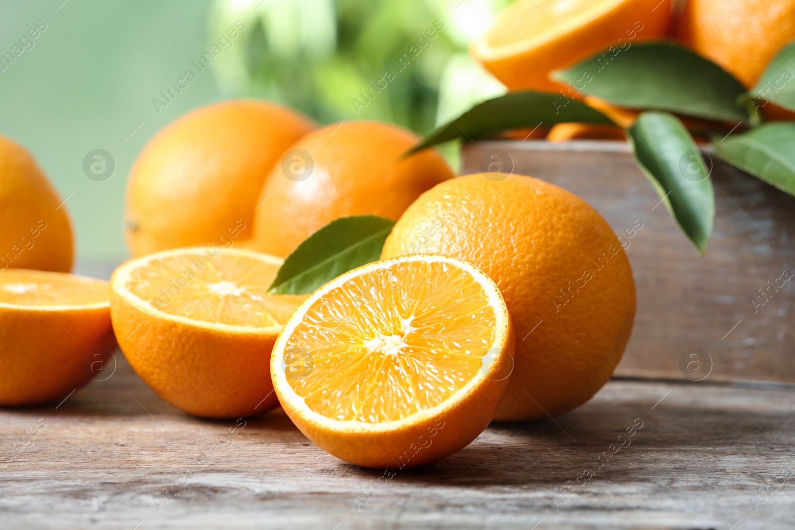 Photo of Ripe oranges on table against blurred background