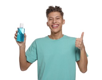 Photo of Young man with mouthwash showing thumbs up on white background