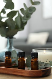 Aromatherapy. Bottles of essential oil and eucalyptus leaves on table