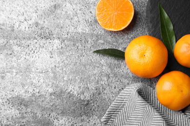 Photo of Fresh ripe tangerines on grey table, flat lay. Space for text