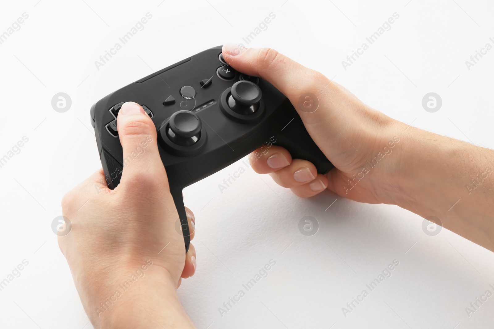 Photo of Young woman holding video game controller on white background, closeup