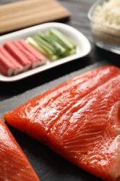 Fresh salmon for sushi on black table, closeup