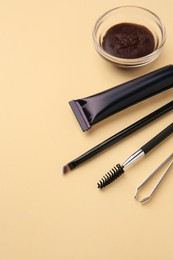 Photo of Eyebrow henna and tools on beige background. Space for text