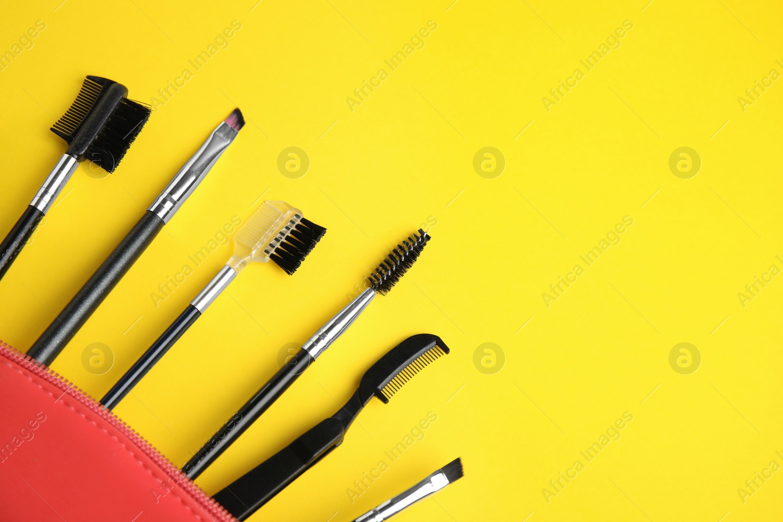 Photo of Set of professional eyebrow tools on yellow background. Space for text