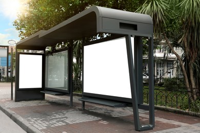 Photo of Public transport stop with blank advertisement board on city street