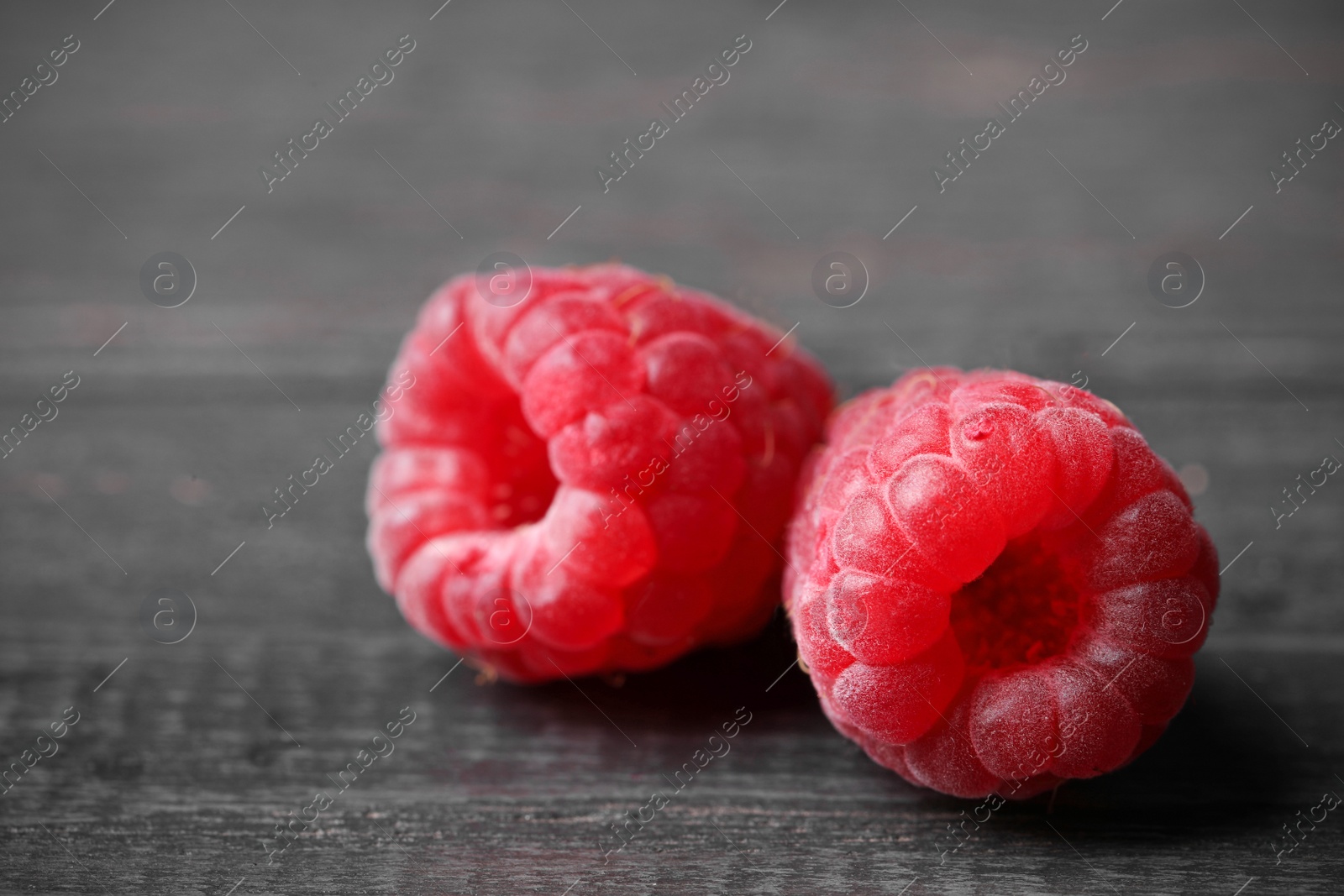 Photo of Delicious fresh ripe raspberries on dark wooden table, closeup view. Space for text