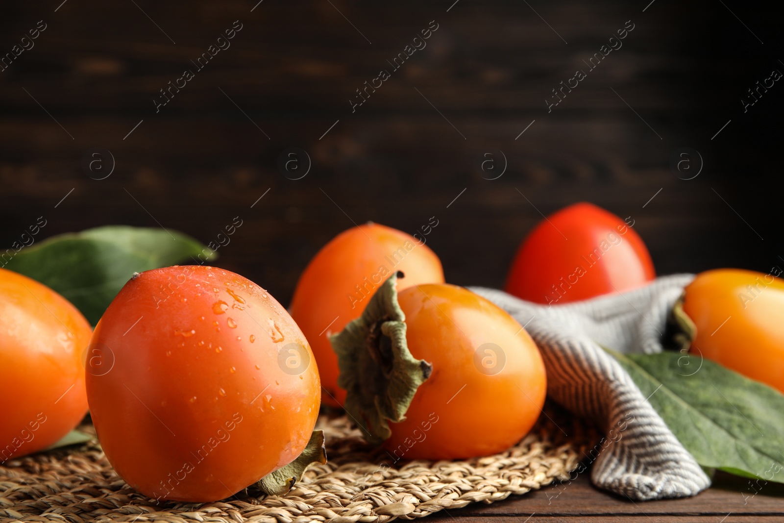 Photo of Delicious fresh persimmon fruits on table, closeup