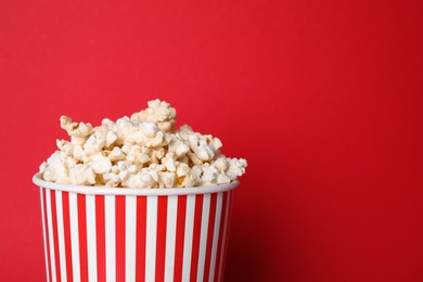 Delicious popcorn on red background, closeup. Space for text