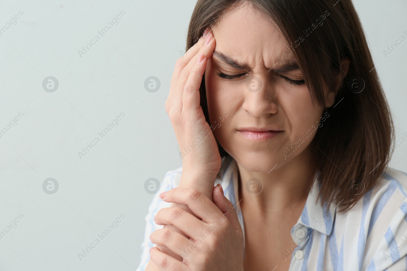 Photo of Young woman suffering from migraine on white background. Space for text