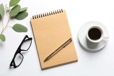 Photo of Flat lay composition with notebook, cup of coffee and glasses on white background