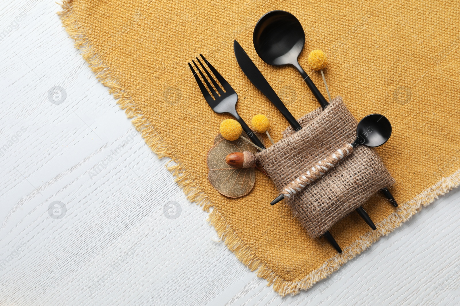 Photo of Top view of autumn place setting with cutlery on white wooden table, space for text