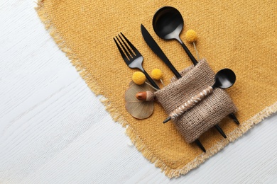 Top view of autumn place setting with cutlery on white wooden table, space for text