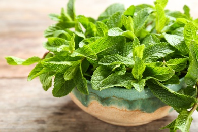 Bowl with fresh mint on wooden table