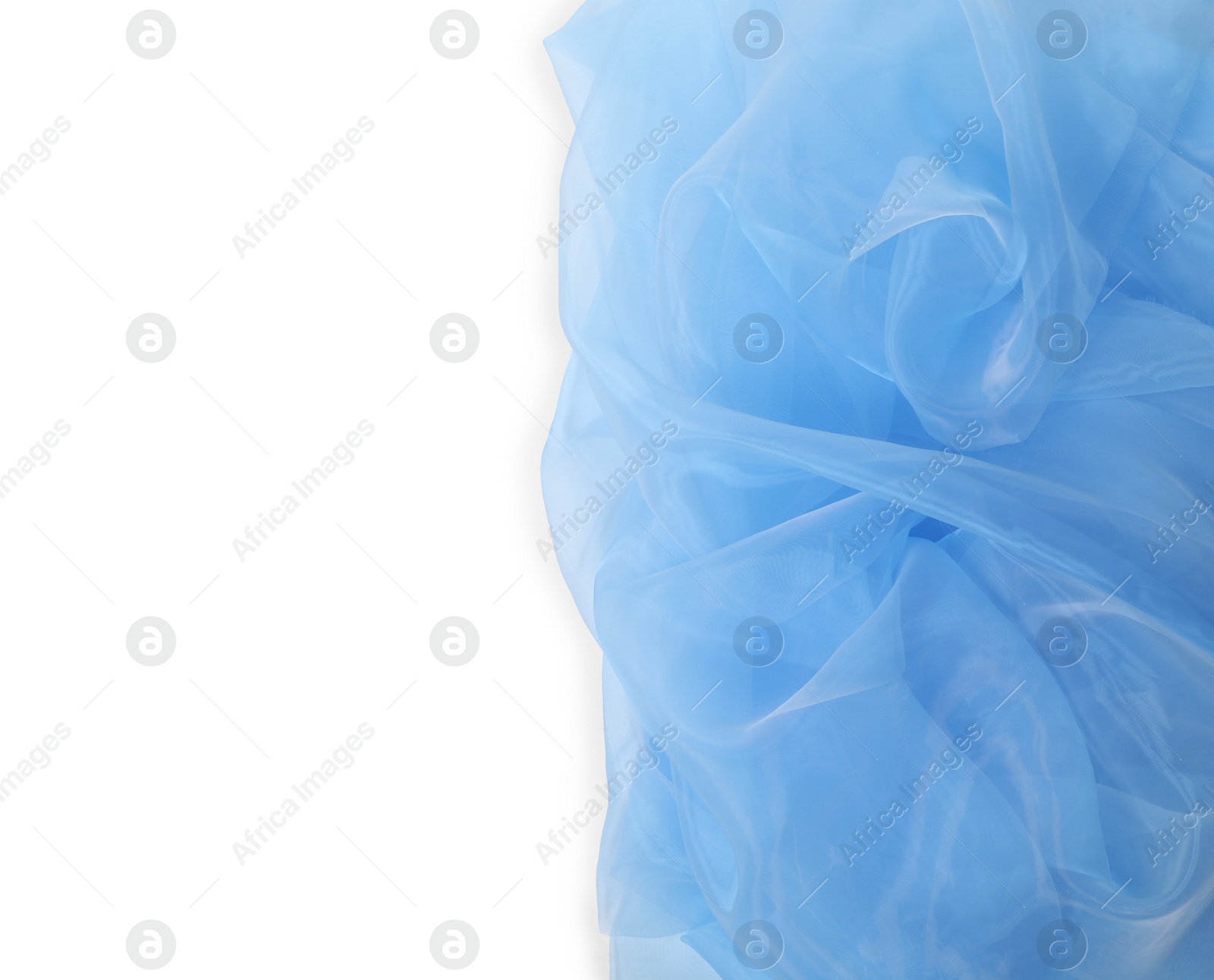 Photo of Beautiful light blue tulle fabric on white background, top view. Space for text