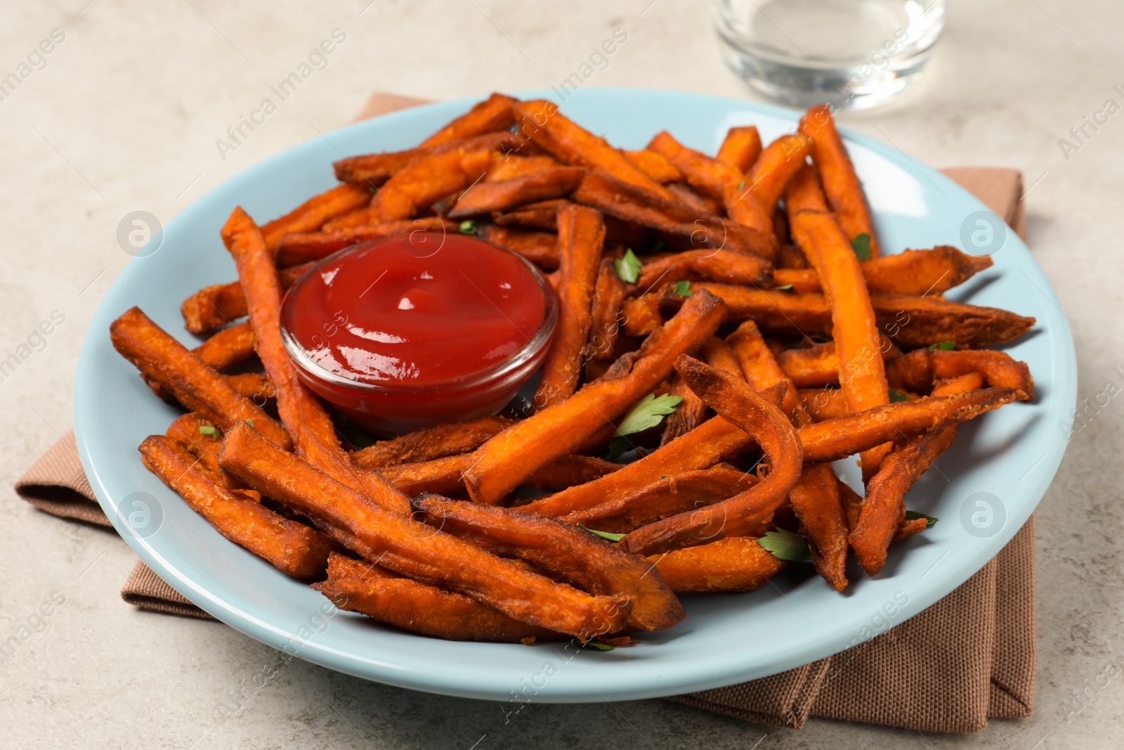 Photo of Delicious sweet potato fries served with sauce on table, closeup