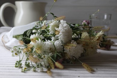 Photo of Bouquet of beautiful wild flowers and spikelets on table, closeup