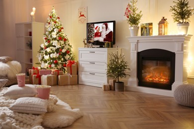 Image of Stylish living room interior with TV set, Christmas tree and fireplace