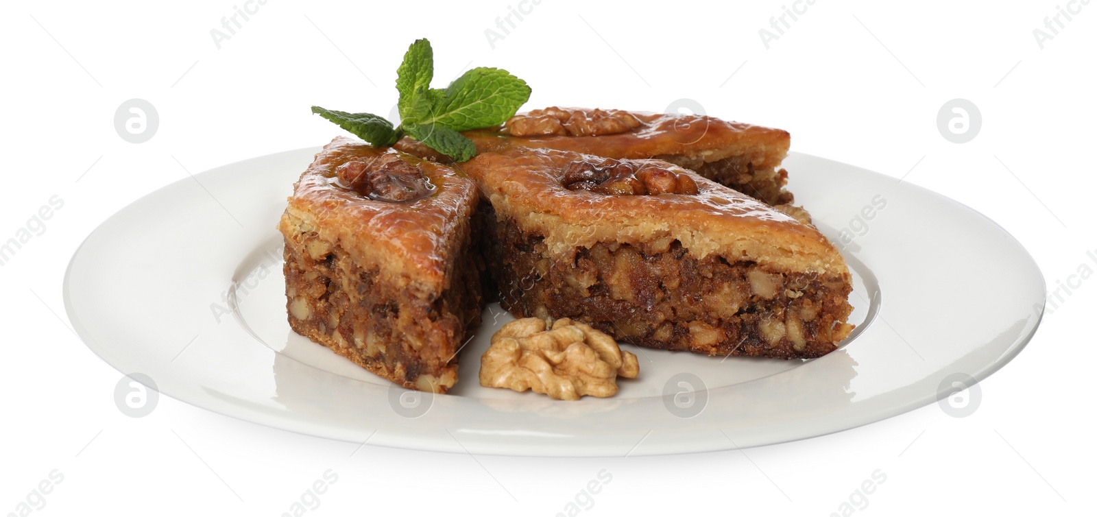 Photo of Plate of delicious honey baklava with walnuts on white background