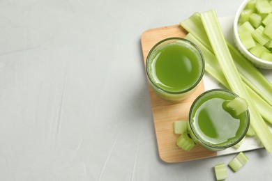 Photo of Celery juice and fresh vegetables on light gray table, flat lay. Space for text