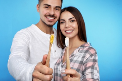 Photo of Happy couple with toothbrushes on color background. Teeth care