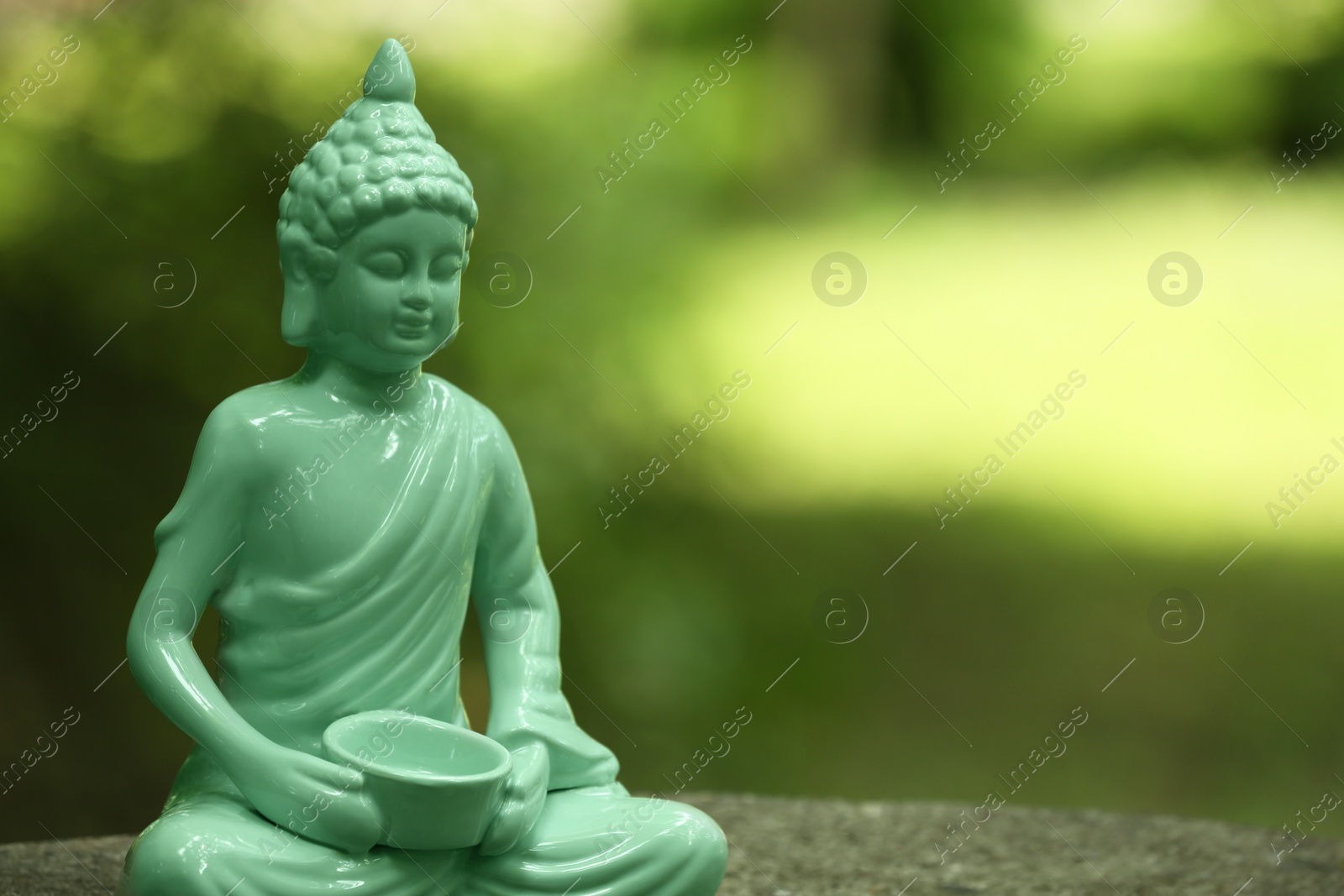 Photo of Decorative Buddha statue on blurred background, closeup. Space for text