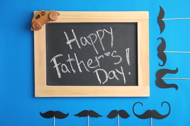 Photo of Flat lay composition with blackboard and moustaches on color background. Happy Father's Day