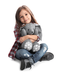 Photo of Cute little girl with toy bunny on white background
