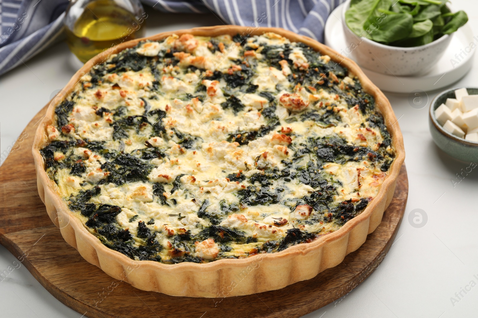 Photo of Delicious homemade spinach quiche on white table, closeup