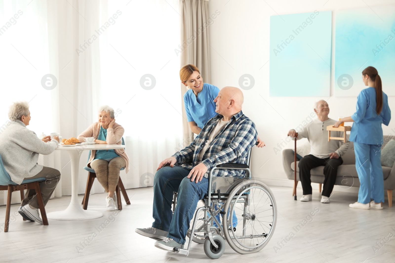 Photo of Nurses assisting elderly people at retirement home